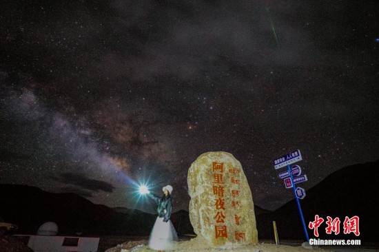 圖為6月20日晚，游客“打卡”西藏阿里暗夜公園，天上是銀河與流星（右上角）。曹枝清 攝