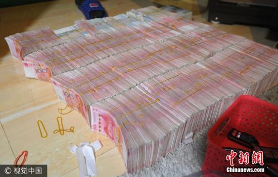 廣西南寧警方8月21日通報，當?shù)亟粘晒善粕姘附痤~15.19億元人民幣的特大傳銷案件。圖為當場繳獲的成捆現(xiàn)金。圖片來源：視覺中國